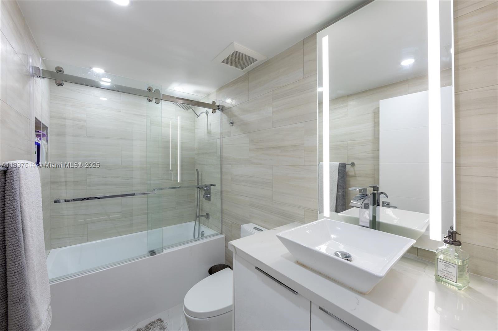 701 Brickell Key Boulevard, Unit 2011 Miami, FL 33131 - Photo 11 of 24 a bathroom with a shower a sink and a toilet