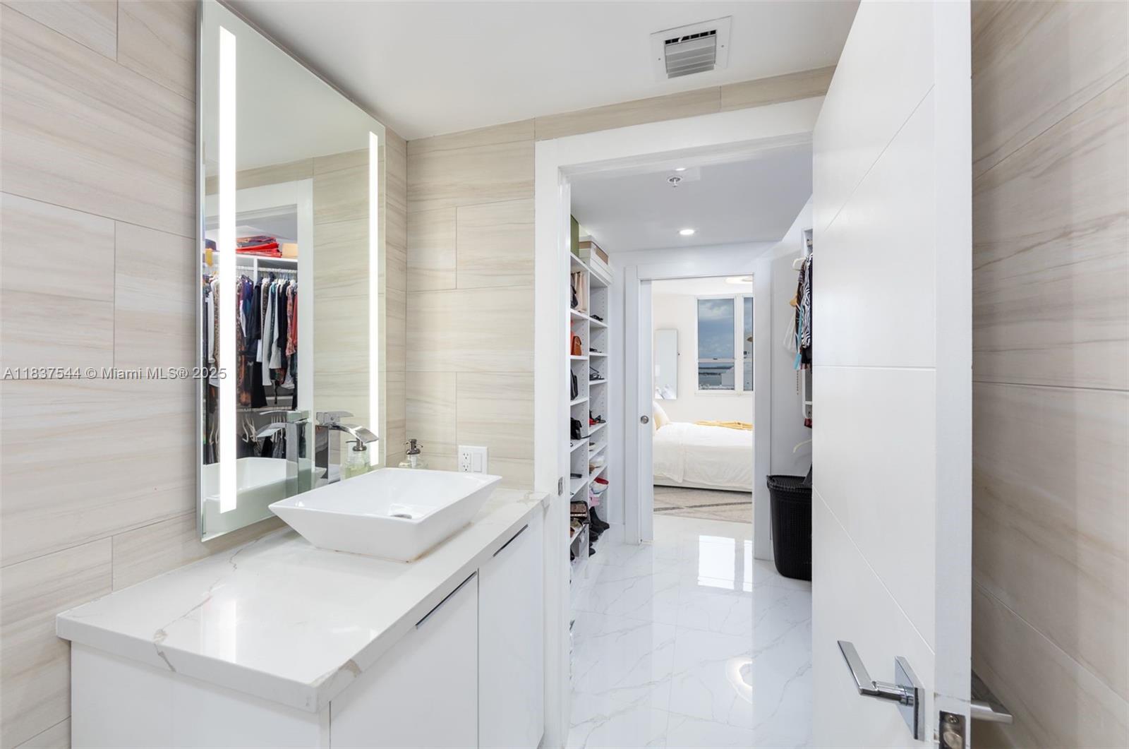 701 Brickell Key Boulevard, Unit 2011 Miami, FL 33131 - Photo 12 of 24 a en suite bathroom with a sink a mirror and a shower