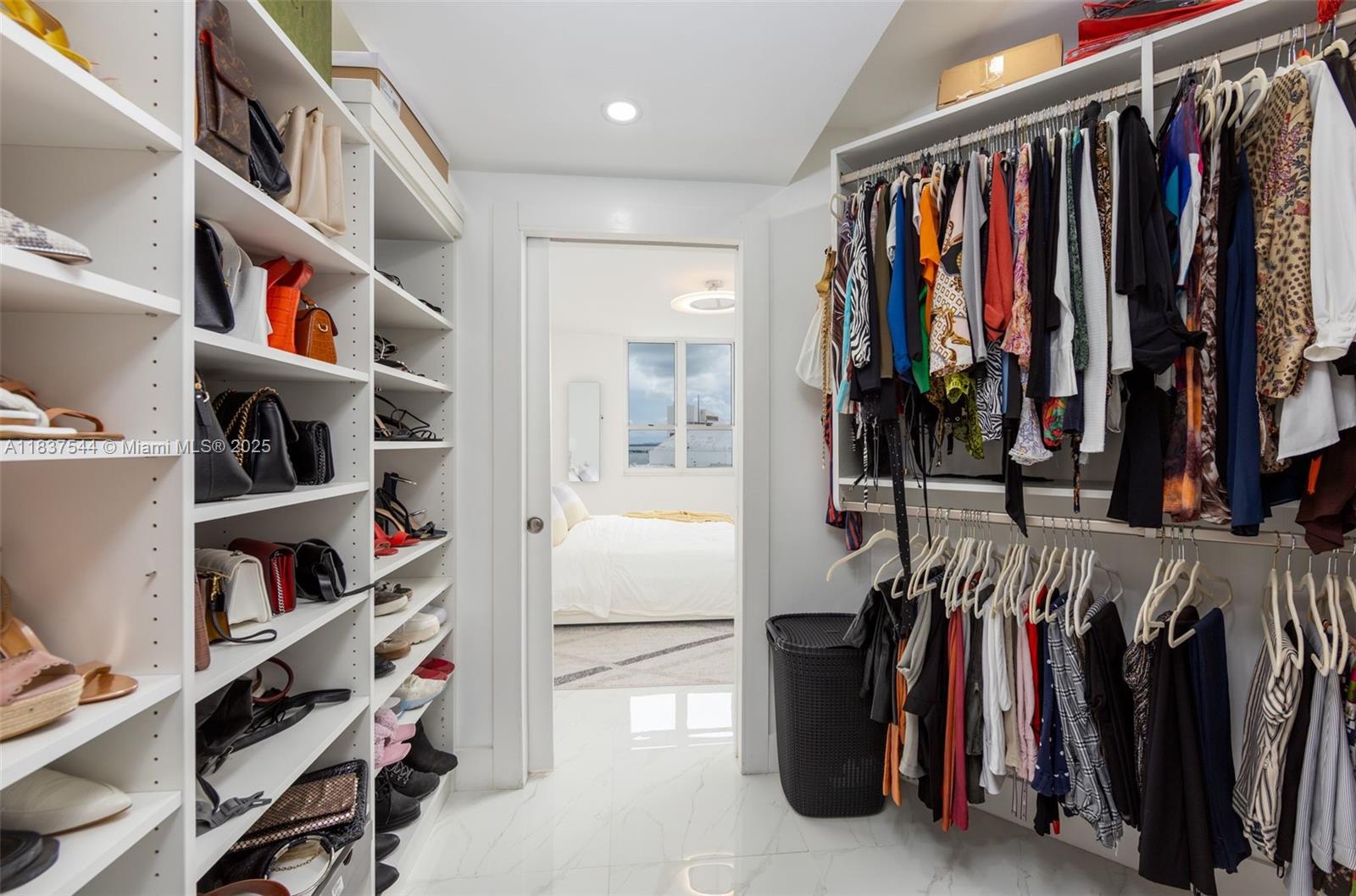 701 Brickell Key Boulevard, Unit 2011 Miami, FL 33131 - Photo 13 of 24 a view of walk in closet with clothes and shoes