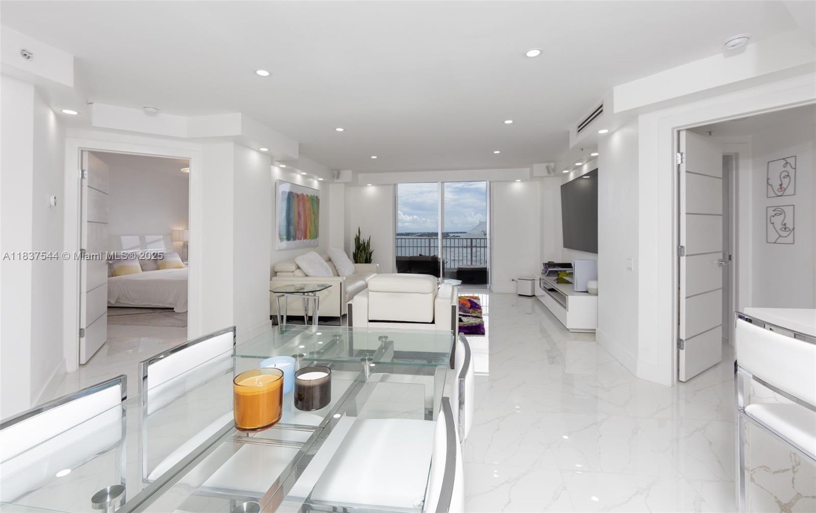 701 Brickell Key Boulevard, Unit 2011 Miami, FL 33131 - Photo 4 of 24 a dining room with stainless steel appliances furniture a rug and a view