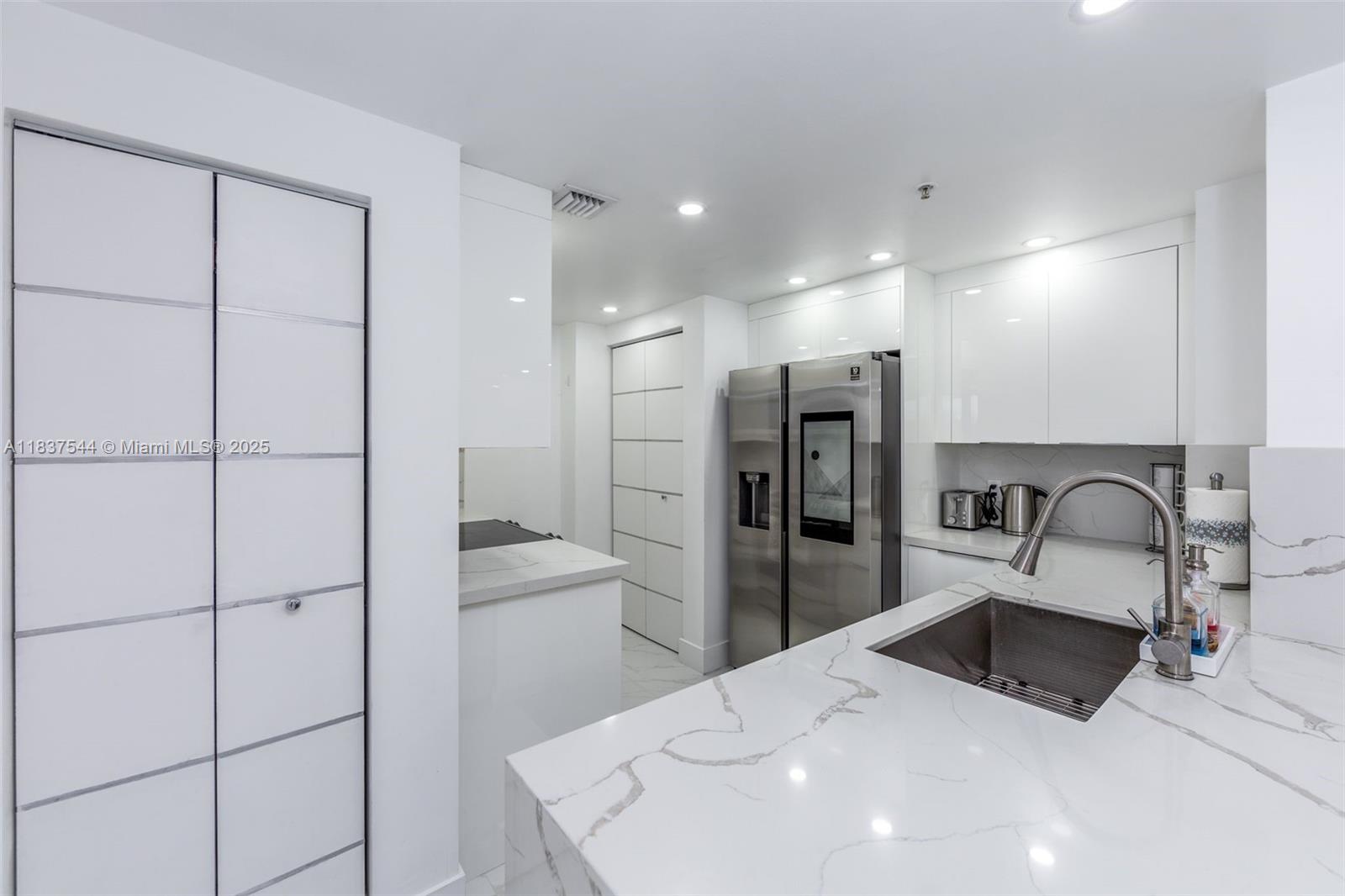 701 Brickell Key Boulevard, Unit 2011 Miami, FL 33131 - Photo 5 of 24 a kitchen with a refrigerator a sink and cabinets