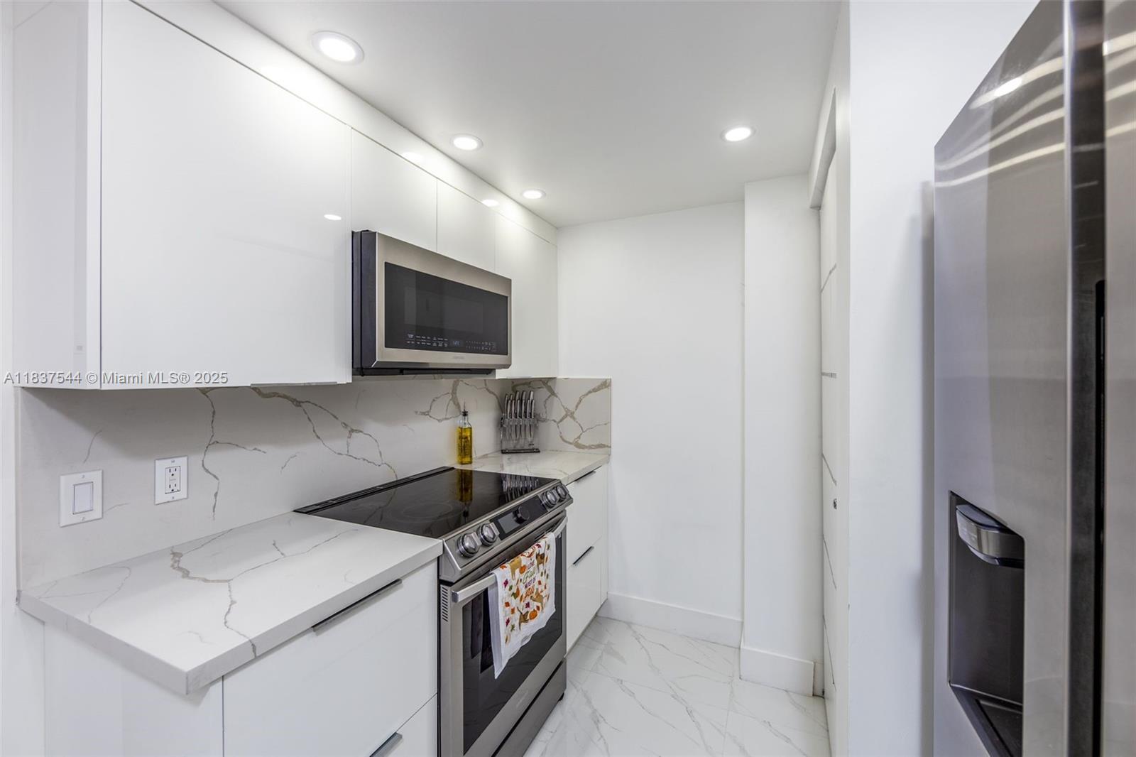 701 Brickell Key Boulevard, Unit 2011 Miami, FL 33131 - Photo 7 of 24 a kitchen with a sink a stove and cabinets