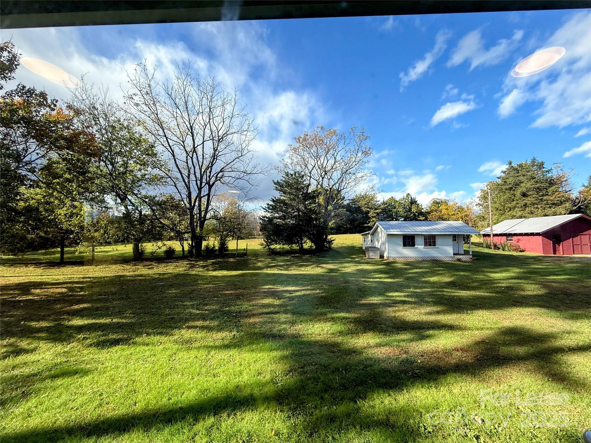 7135 Nc Highway Mill Spring, NC 28756 - Photo 27 of 28 a view of a fountain in front of a house with a big yard
