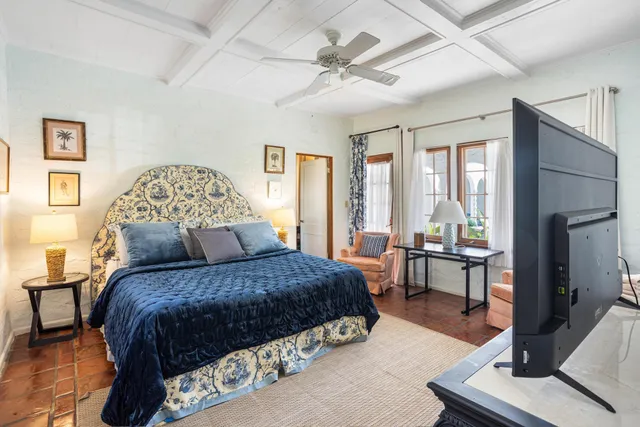 a bedroom with a balcony a bed and a table chair