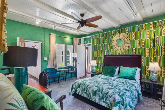 a bedroom with a bed mirror and a large window