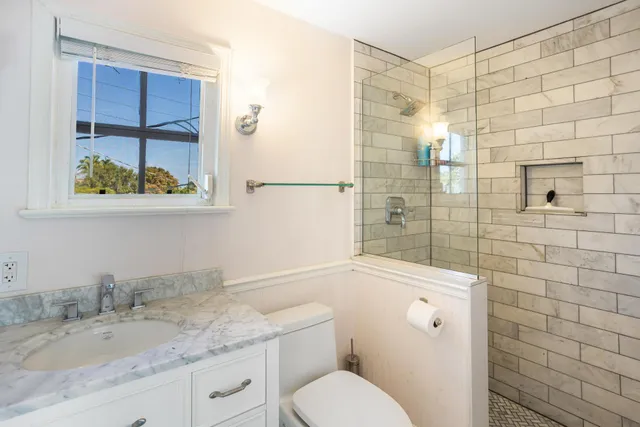 a bathroom with a granite countertop toilet sink and shower