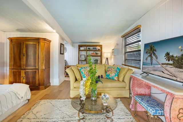 a living room with furniture flowerpot and wooden floor