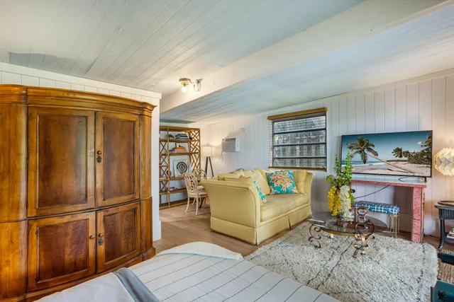 a living room with furniture a red rug and white walls