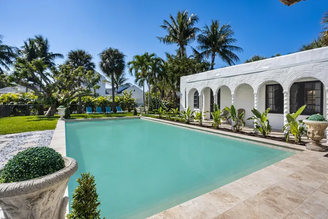 a front view of a house with swimming pool having outdoor seating