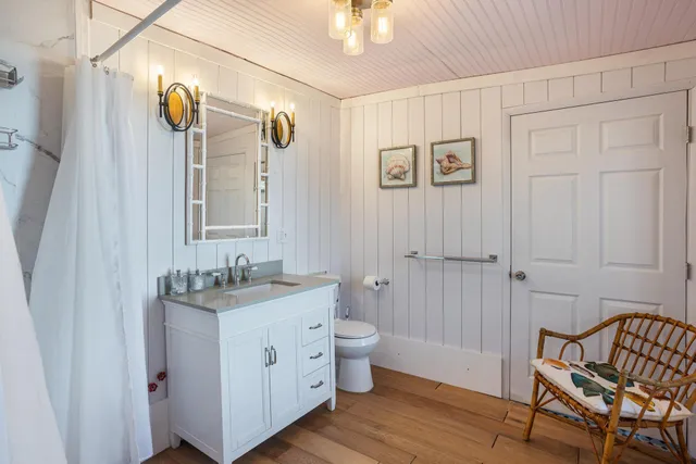 a bathroom with a sink a toilet and mirror