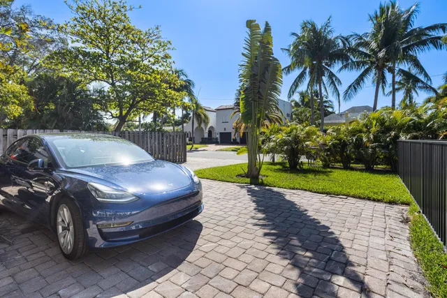 a car parked in front of a house with a yard