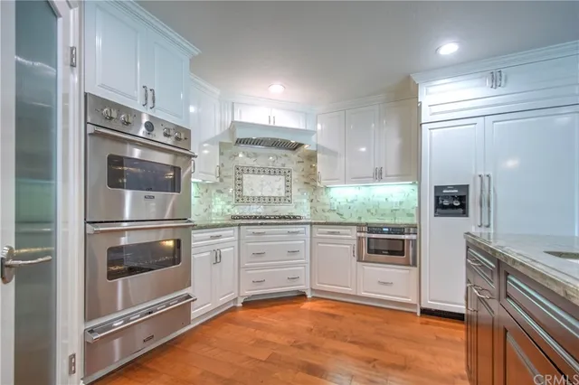 a view of a kitchen with kitchen island granite countertop a large counter top stainless steel appliances and cabinets