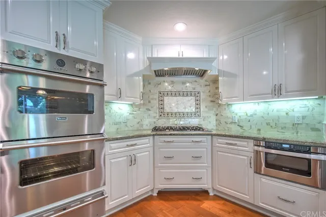 a kitchen with stainless steel appliances granite countertop a sink and stove