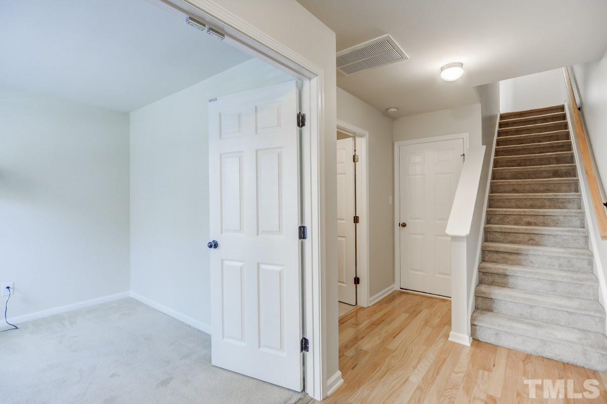 9813 Castain Drive Raleigh, NC 27617 - Photo 2 of 16 a view of hallway with stairs and wooden floor