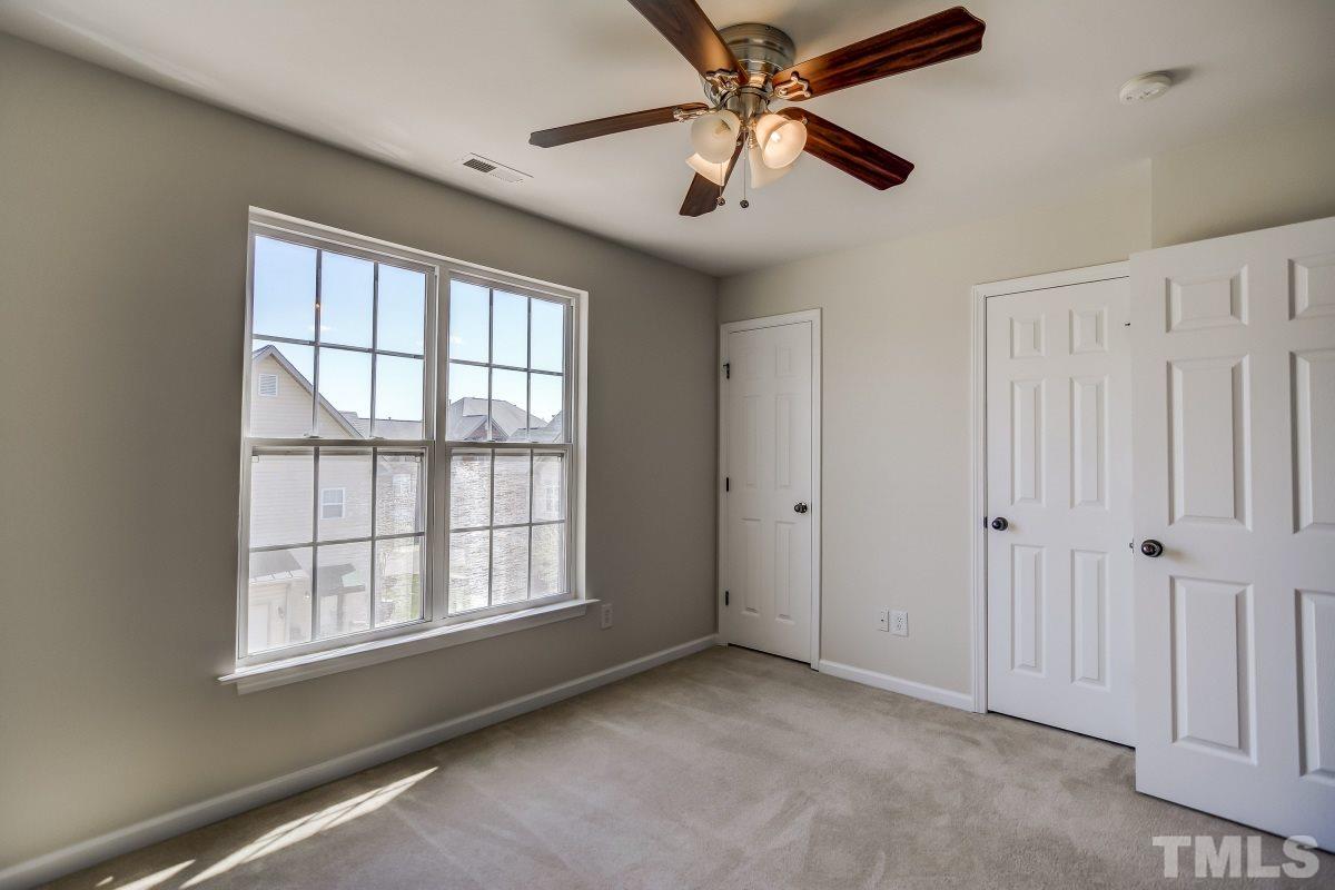 9813 Castain Drive Raleigh, NC 27617 - Photo 13 of 16 an empty room with chandelier fan and windows