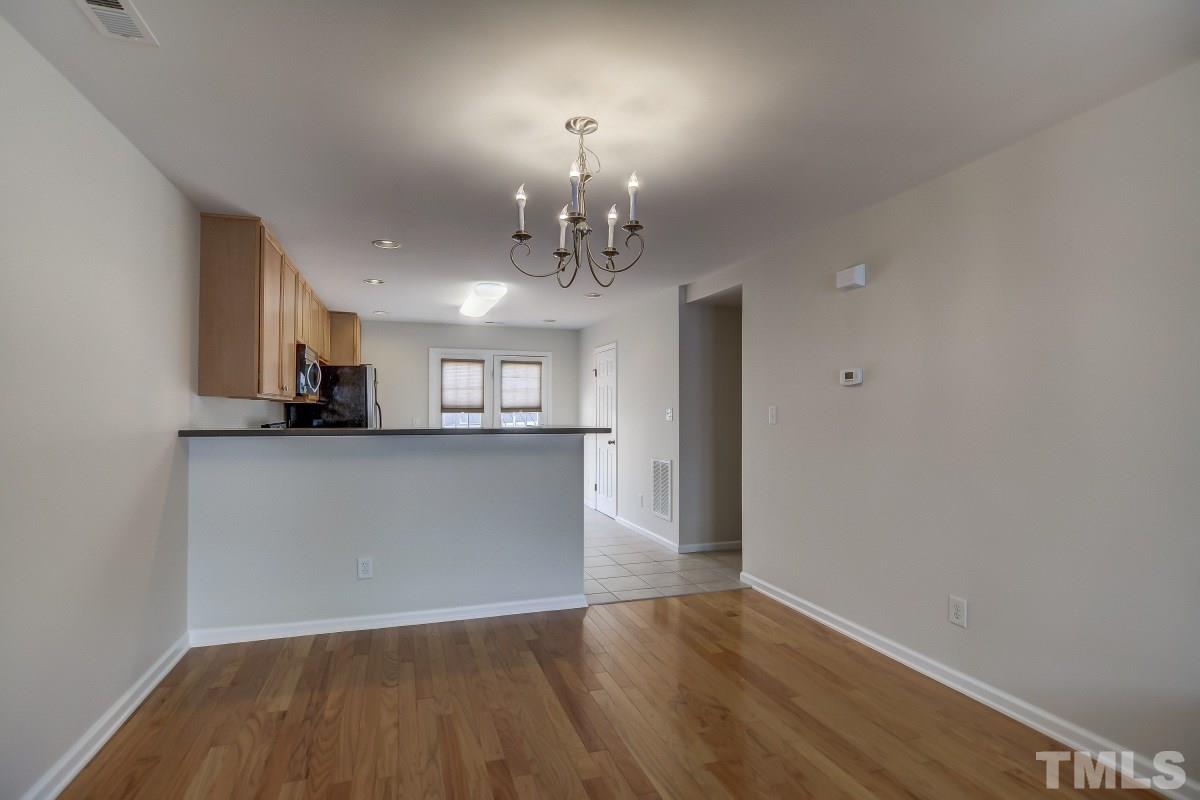 9813 Castain Drive Raleigh, NC 27617 - Photo 6 of 16 a view of a kitchen with a sink and dishwasher a kitchen view with wooden floor