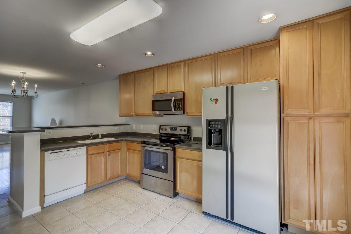 9813 Castain Drive Raleigh, NC 27617 - Photo 8 of 16 a kitchen with stainless steel appliances granite countertop a refrigerator and a stove top oven