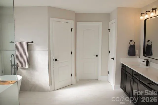 a bathroom with a double vanity sink a toilet and a tub