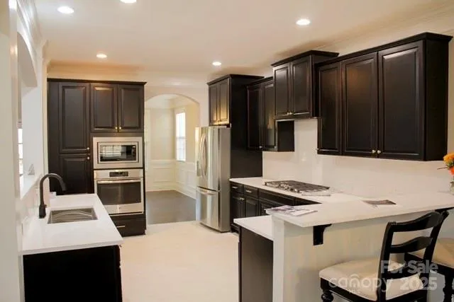 a kitchen with stainless steel appliances kitchen island sink refrigerator and stove