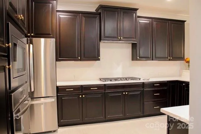 a kitchen with stainless steel appliances granite countertop a refrigerator and a sink
