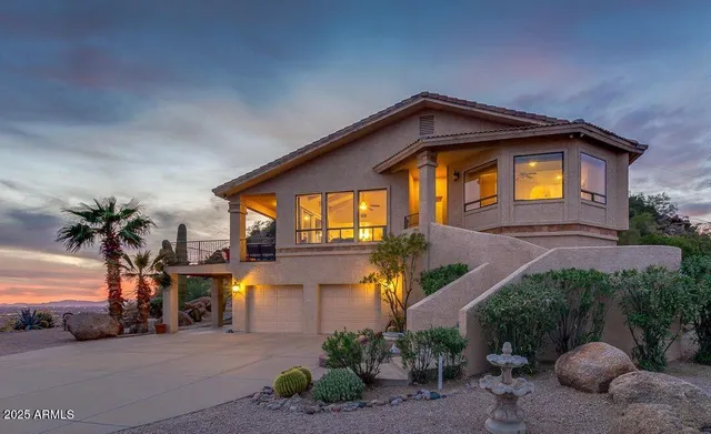 a front view of a house with a yard and potted plants