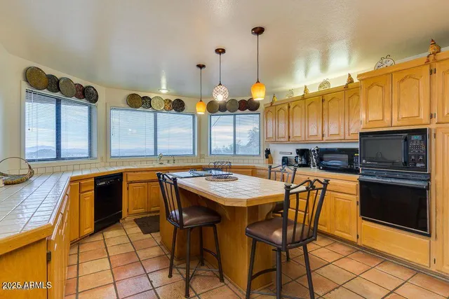 a kitchen with stainless steel appliances granite countertop a stove a sink dishwasher and cabinets with wooden floor