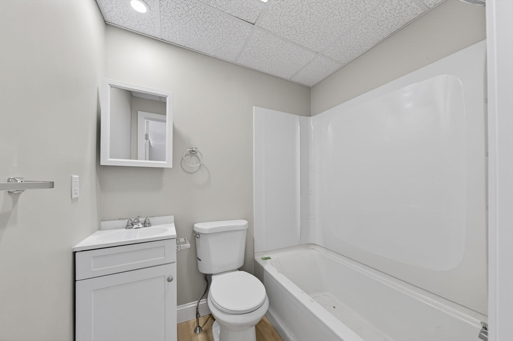 169 Grant Street Fall River, MA 02721 - Photo 13 of 42 a white toilet sitting next to a white sink and vanity