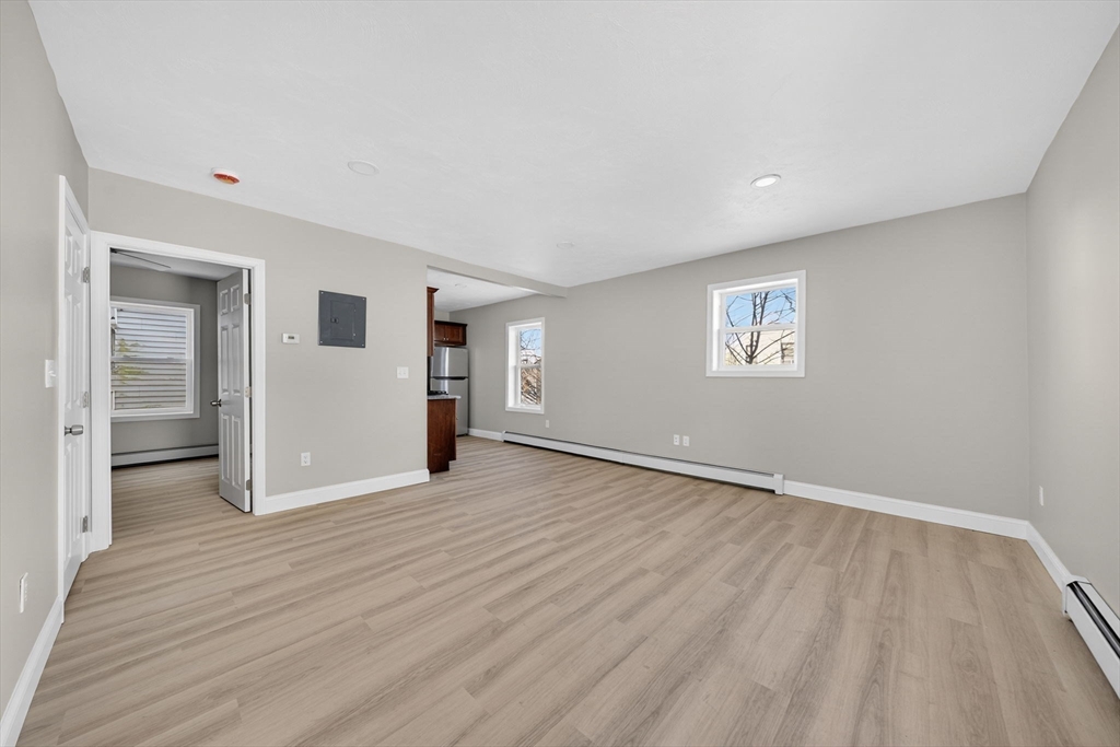 169 Grant Street Fall River, MA 02721 - Photo 14 of 42 an empty room with wooden floor and windows
