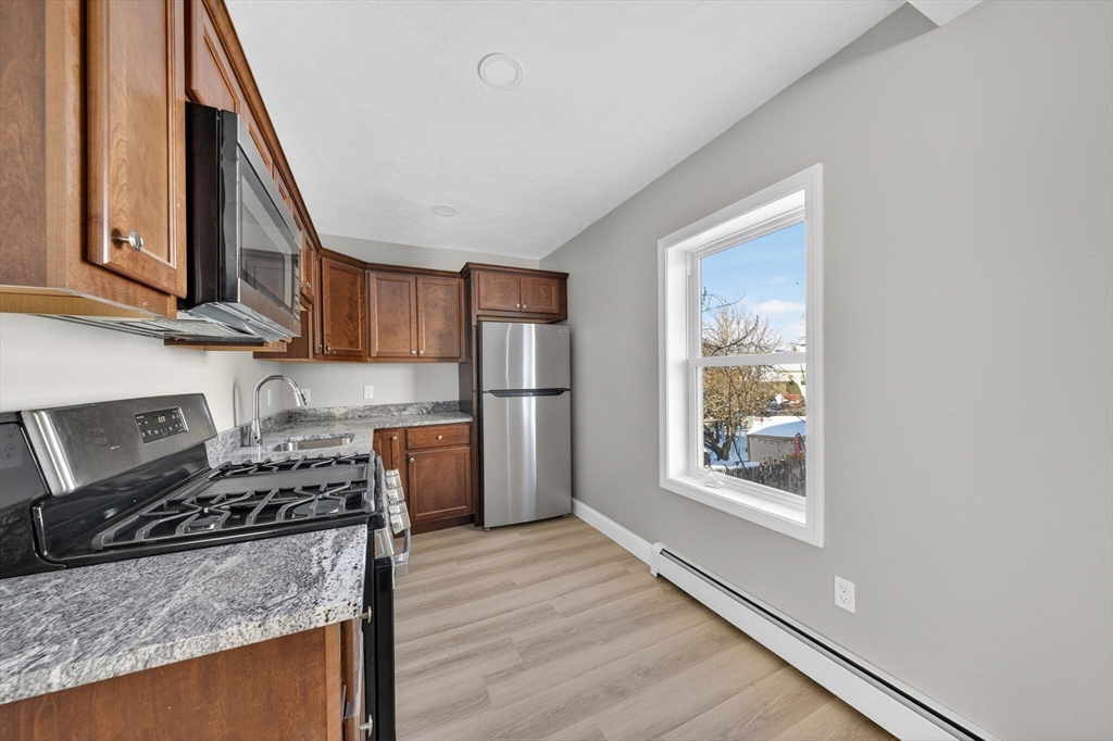 169 Grant Street Fall River, MA 02721 - Photo 17 of 42 a kitchen with stainless steel appliances granite countertop a stove a sink and a refrigerator
