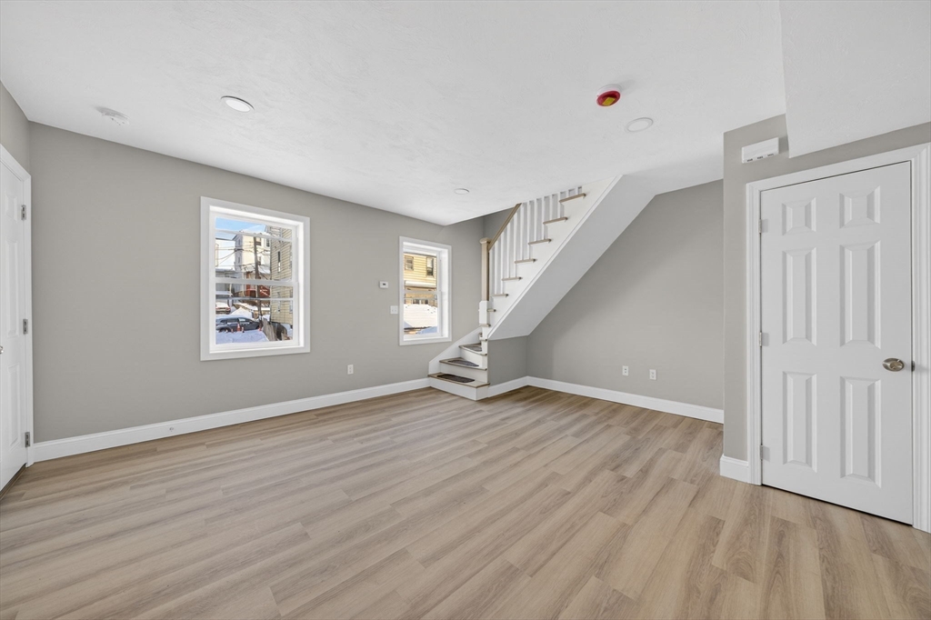 169 Grant Street Fall River, MA 02721 - Photo 24 of 42 an empty room with wooden floor and windows
