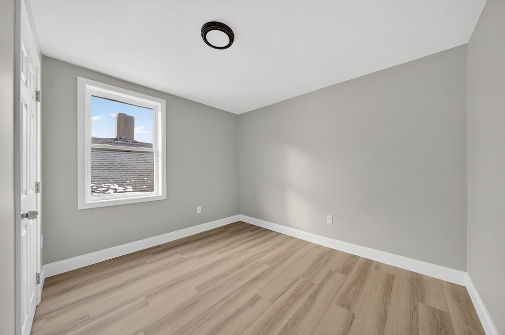 169 Grant Street Fall River, MA 02721 - Photo 36 of 42 an empty room with wooden floor and windows