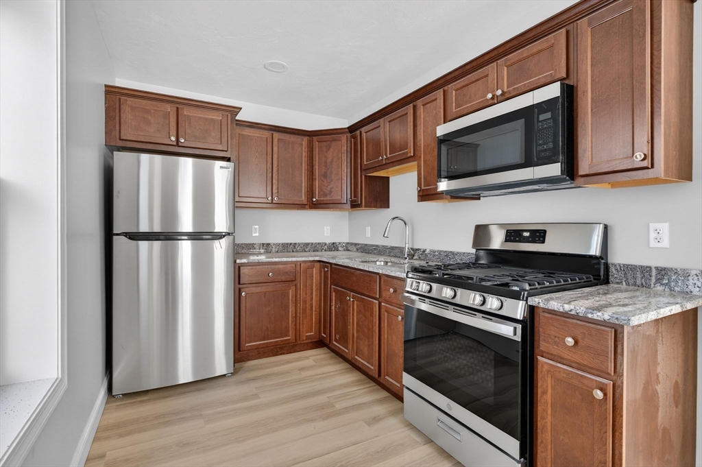 169 Grant Street Fall River, MA 02721 - Photo 9 of 42 a kitchen with a stove microwave and refrigerator