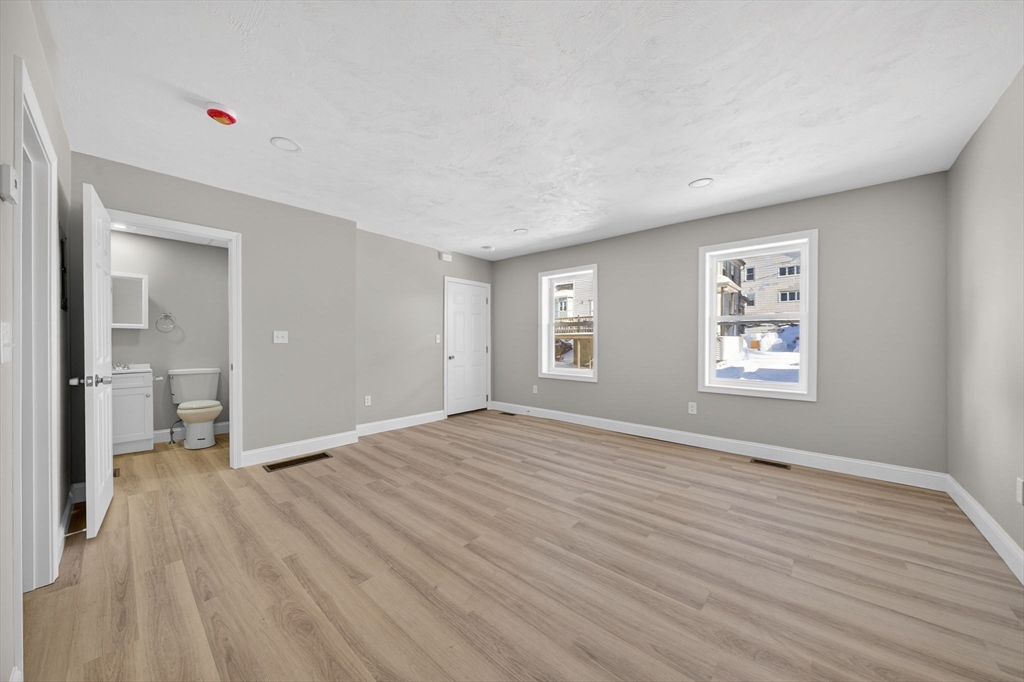 169 Grant Street Fall River, MA 02721 - Photo 10 of 42 a view of an empty room with wooden floor and a window