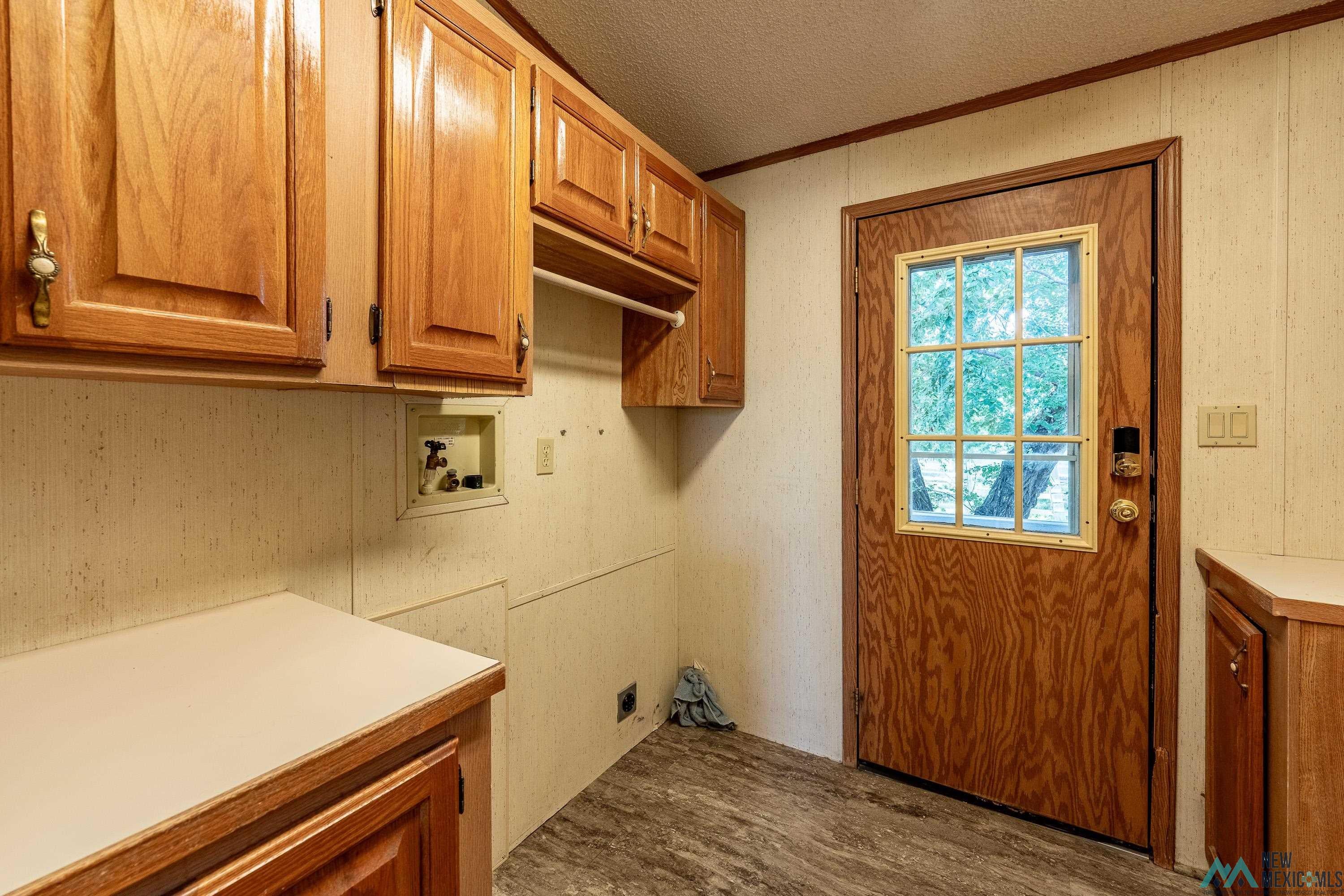35234 Highway 87 Raton, NM 87740 - Photo 56 of 90 Laundry area with dark wood-style floors, crown molding, a textured ceiling, hookup for a washing machine, and cabinet space