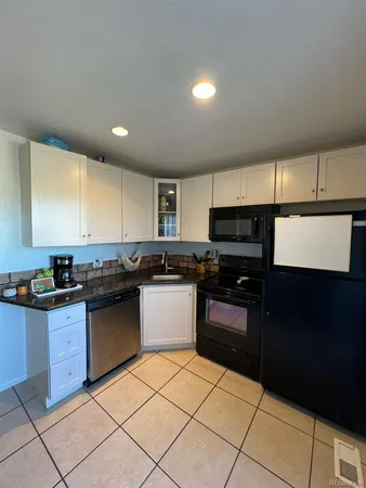 a kitchen with granite countertop a refrigerator and a sink