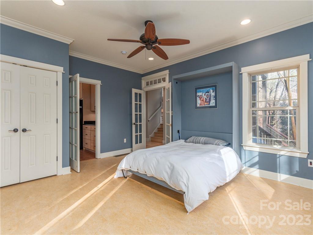 175 Red Oak Road Marshall, NC 28753 - Photo 12 of 34 a spacious bedroom with a large bed chandelier and a window