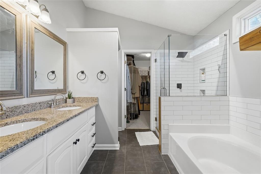 3295 Dundee Ridge Way Duluth, GA 30096 - Photo 17 of 34 a bathroom with a granite countertop sink and a bathtub
