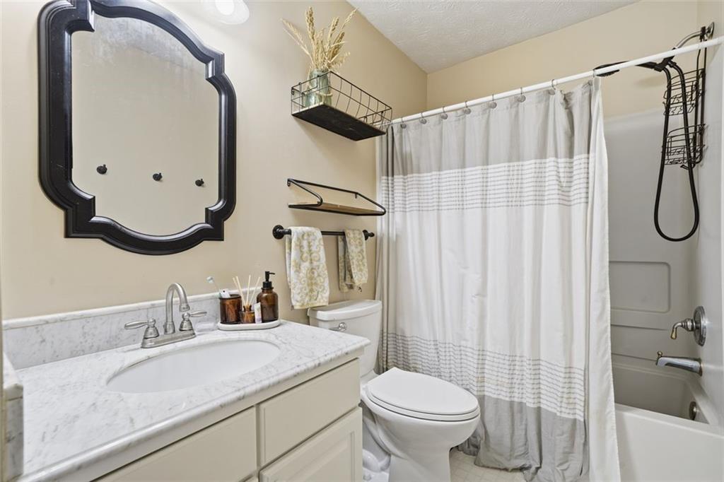 3295 Dundee Ridge Way Duluth, GA 30096 - Photo 22 of 34 a bathroom with a sink a toilet and a mirror