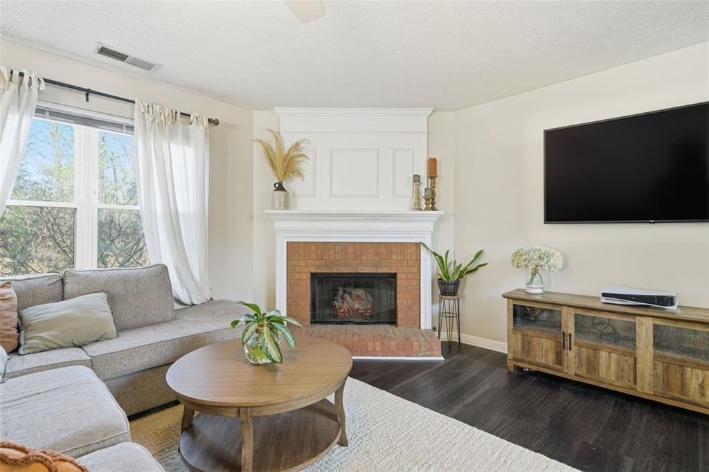 3295 Dundee Ridge Way Duluth, GA 30096 - Photo 6 of 34 a living room with furniture a flat screen tv and a fireplace