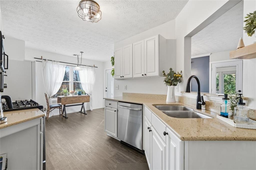 3295 Dundee Ridge Way Duluth, GA 30096 - Photo 9 of 34 a kitchen with a sink cabinets and wooden floor