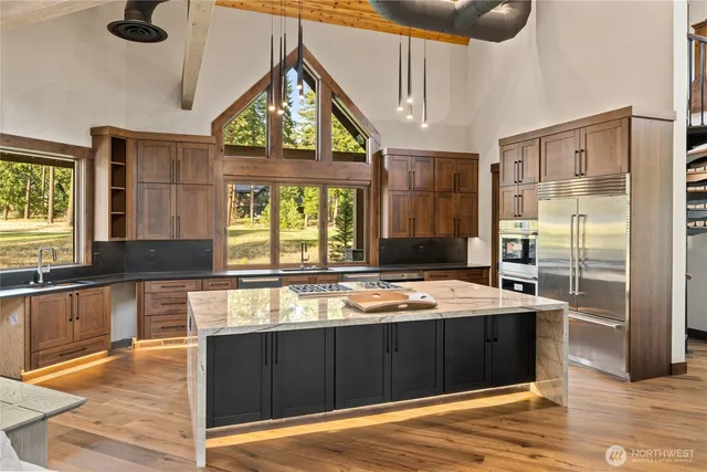 a kitchen with stainless steel appliances granite countertop a stove a sink and a refrigerator