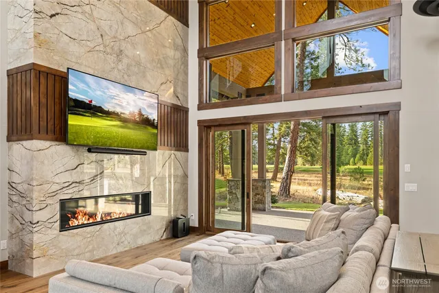 a living room with furniture a flat screen tv and a floor to ceiling window
