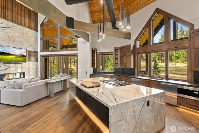 a living room with stainless steel appliances granite countertop furniture and a kitchen view