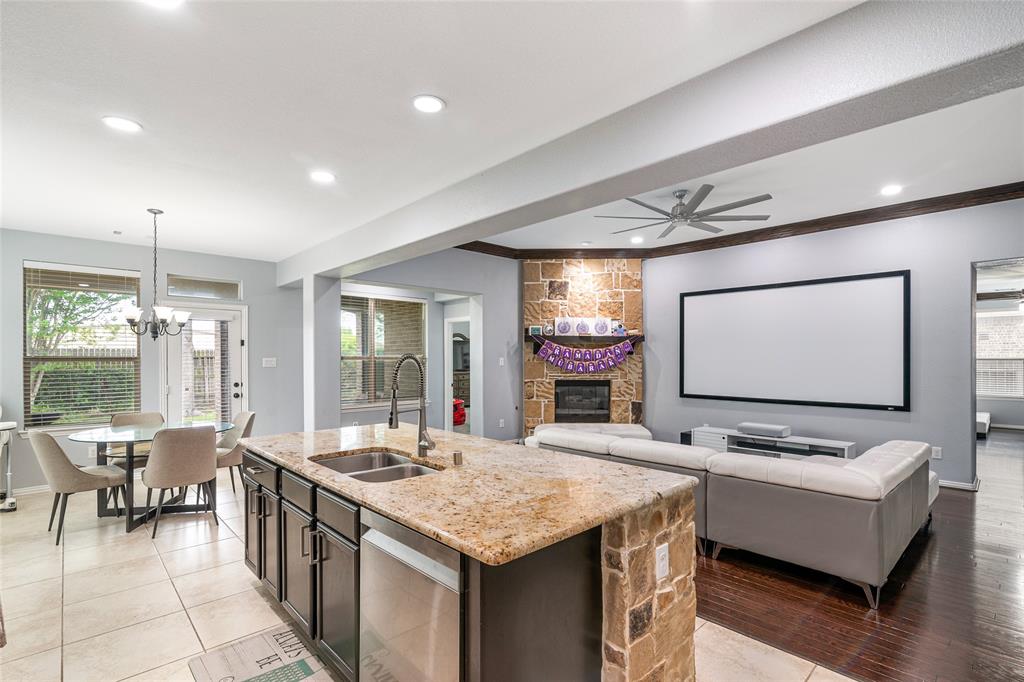 a living room with stainless steel appliances kitchen island granite countertop furniture and a flat screen tv