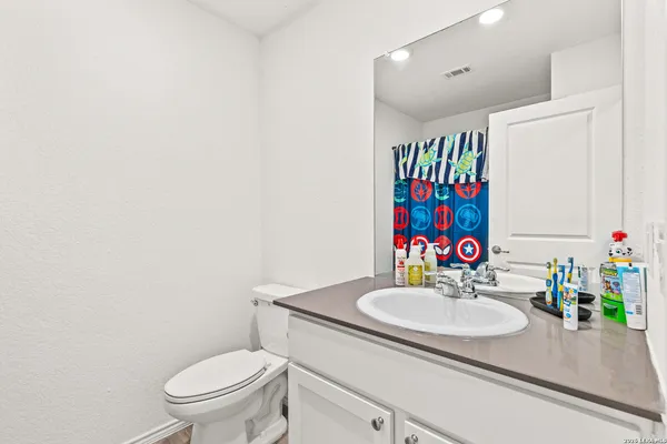a bathroom with a sink vanity mirror and toilet