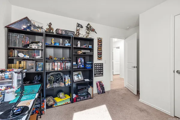 a view of a workspace with bookshelf and a window