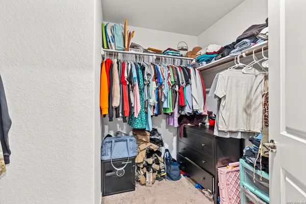 a view of walk in closet with clothes