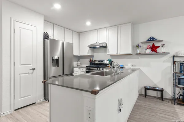 a kitchen with stainless steel appliances granite countertop a refrigerator and a sink