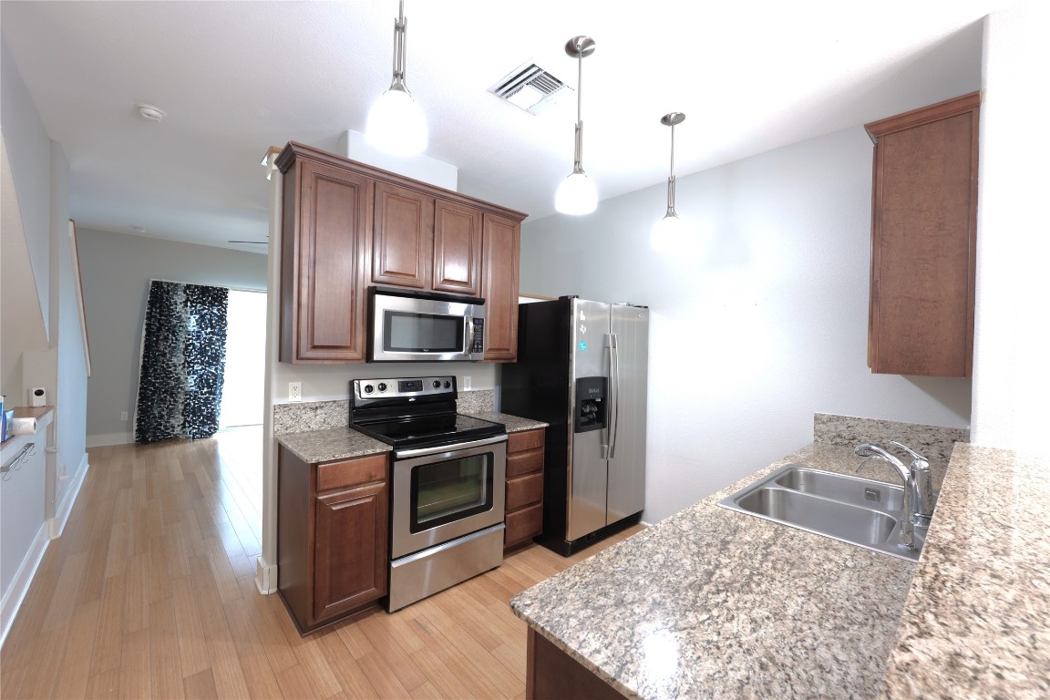 13420 Lyndhurst Street, Unit 304 Austin, TX 78717 - Photo 4 of 17 a kitchen with stainless steel appliances granite countertop a sink refrigerator and microwave