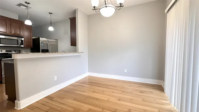 a view of a kitchen with a sink wooden cabinets and stainless steel appliances